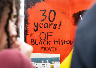A sign reading “30 Years of Black History Month” displayed above a student project display.