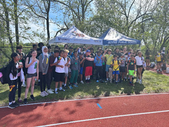 a group of Boyne students standing by the track