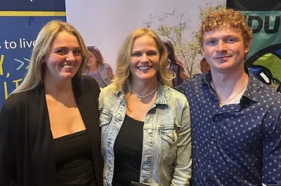 Three people posing for a photo standing side by side. 