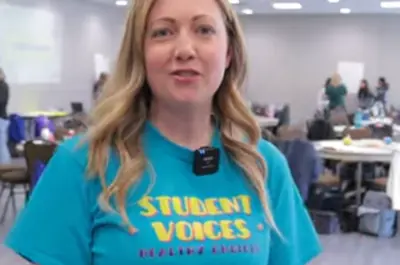close up of a woman wearing a teal t-shirt. 