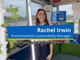 Rachel Irwin, Environmental Sustainability Manager, stands beside a light with sustainability displays, asking, “answer a question for me?”