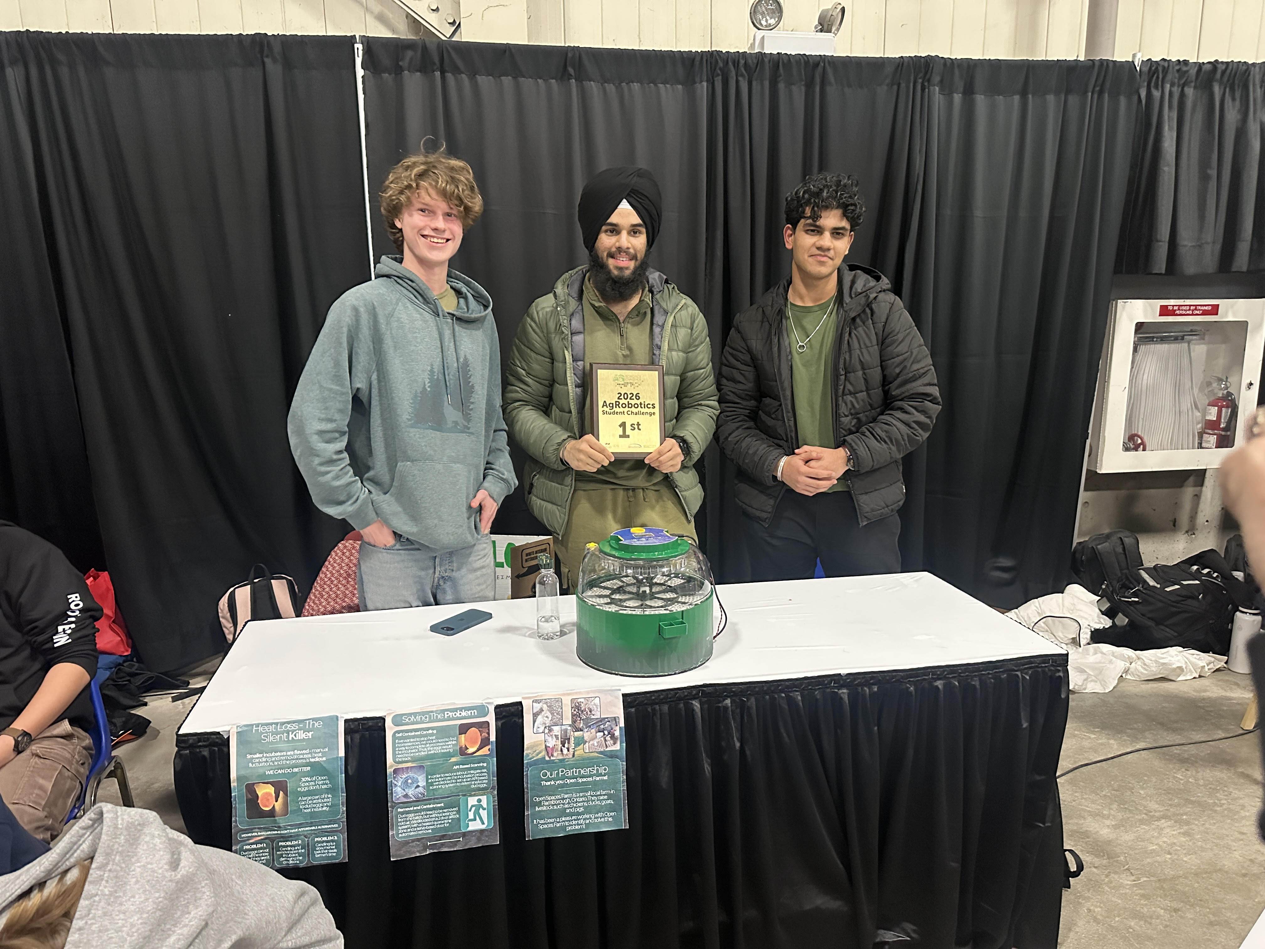 three teenage boys posing with an award.
